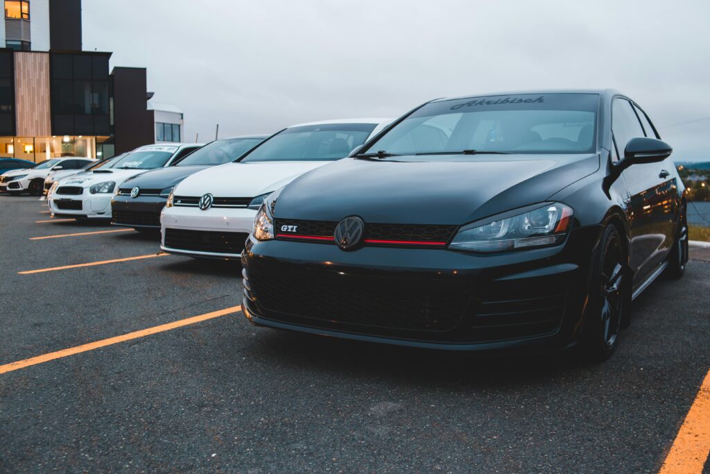 Collection of new contemporary automobiles on shabby roadway in city under cloudy sky